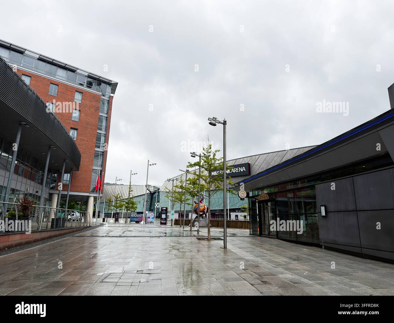 Liverpool, Regno Unito - 16 maggio 2026: Piazza vuota e bagnata a Liverpool fuori dalla M&S Bank Arena, che mostra un'architettura urbana moderna e un marciapiede riflettente. Foto Stock