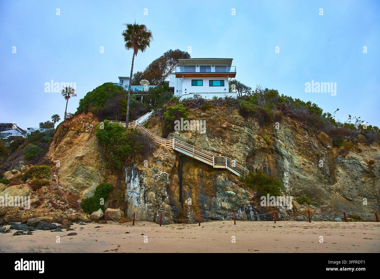 Casa moderna sulla scogliera e costa rocciosa drammatica con vista sulle scale Foto Stock