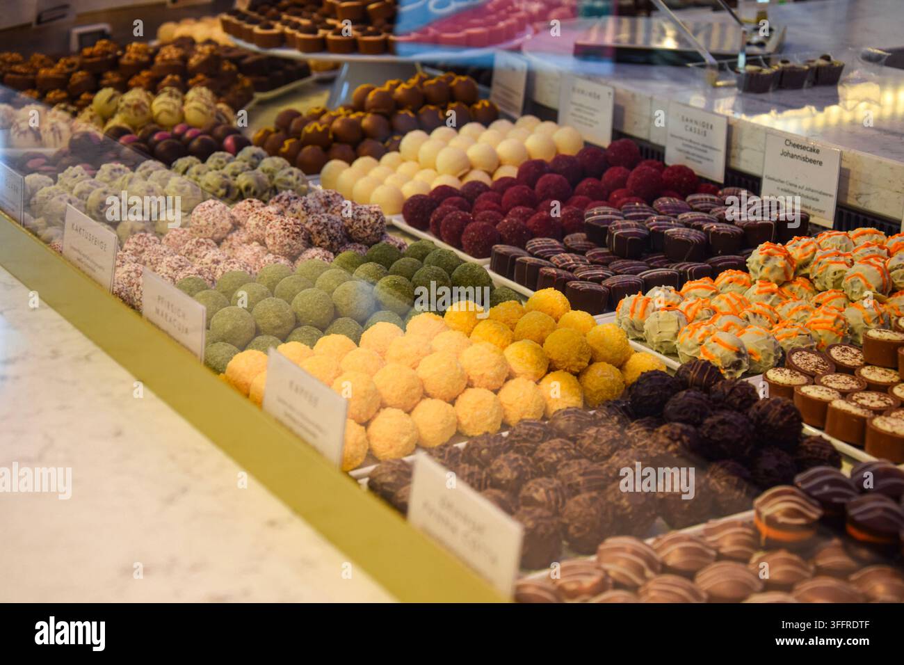 Praline al cioccolato colorate esposte in un caffè a Berlino, Germania Foto Stock