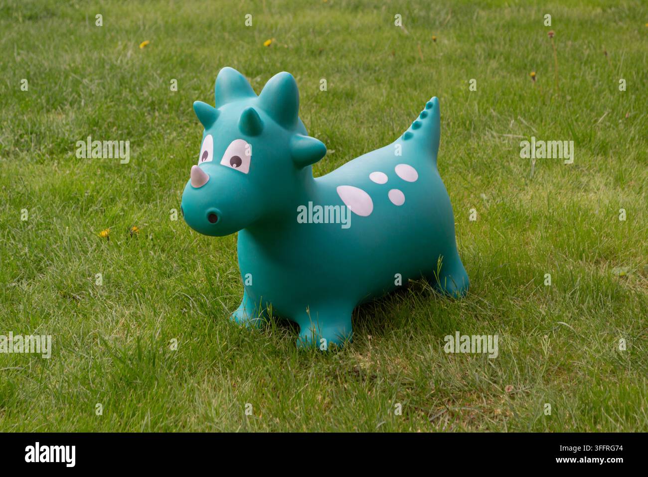 Giocattolo gonfiabile a forma di drago verde sull'erba Foto Stock