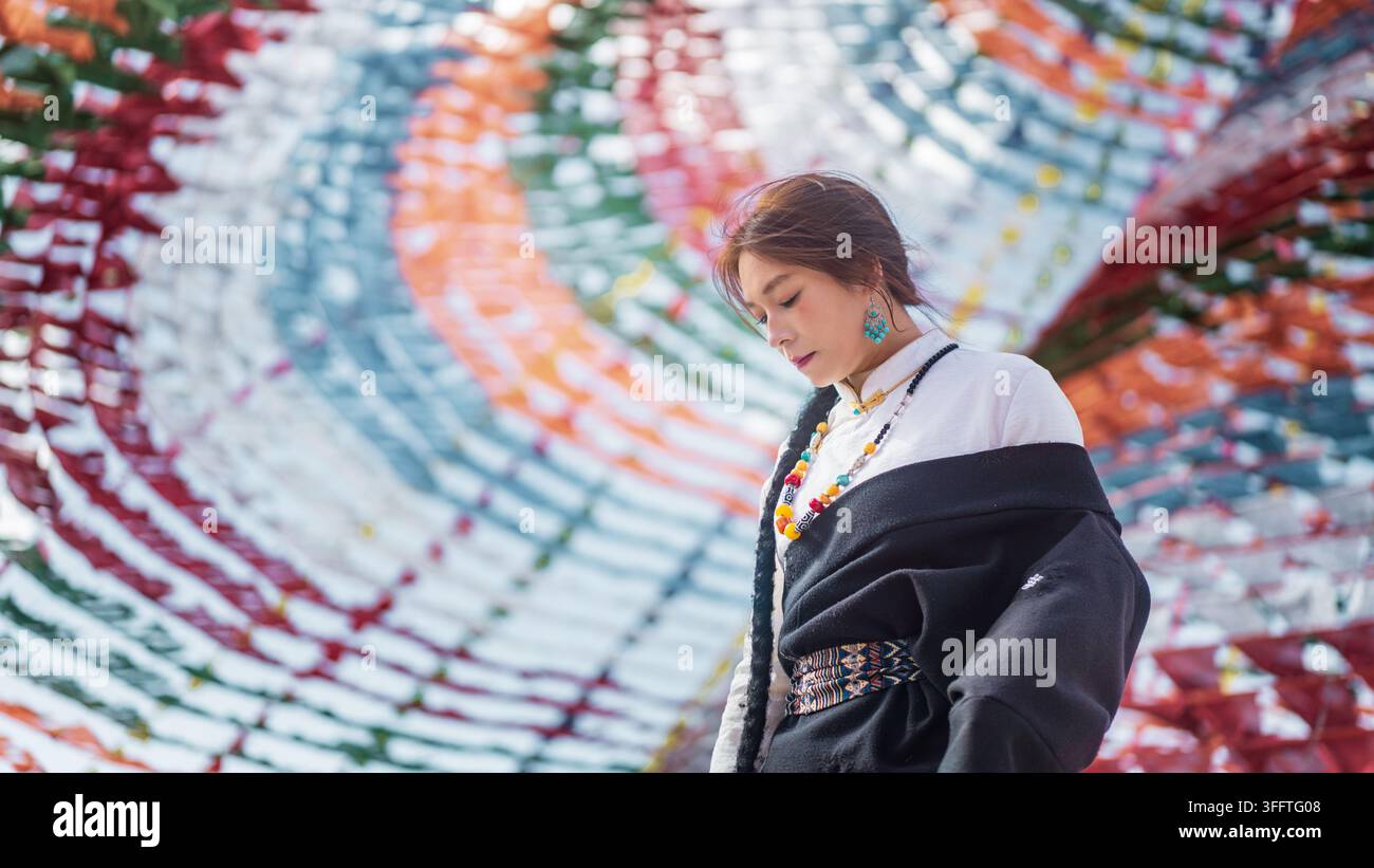 Profilo laterale di una donna sotto un baldacchino con bandiera di preghiera, colori bokeh morbidi sullo sfondo Foto Stock