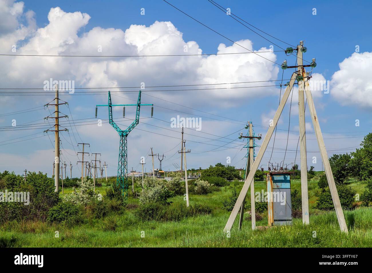 Torri di trasmissione elettrica e linee di potenza in un paesaggio rurale. Foto Stock