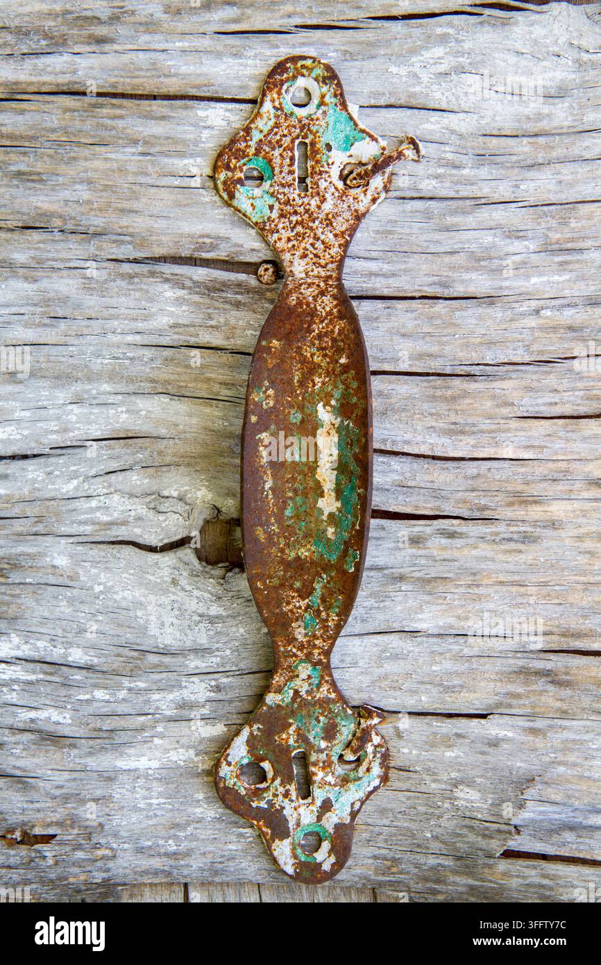 Una vecchia maniglia arrugginita. Una maniglia di porta in ferro antico. Foto Stock