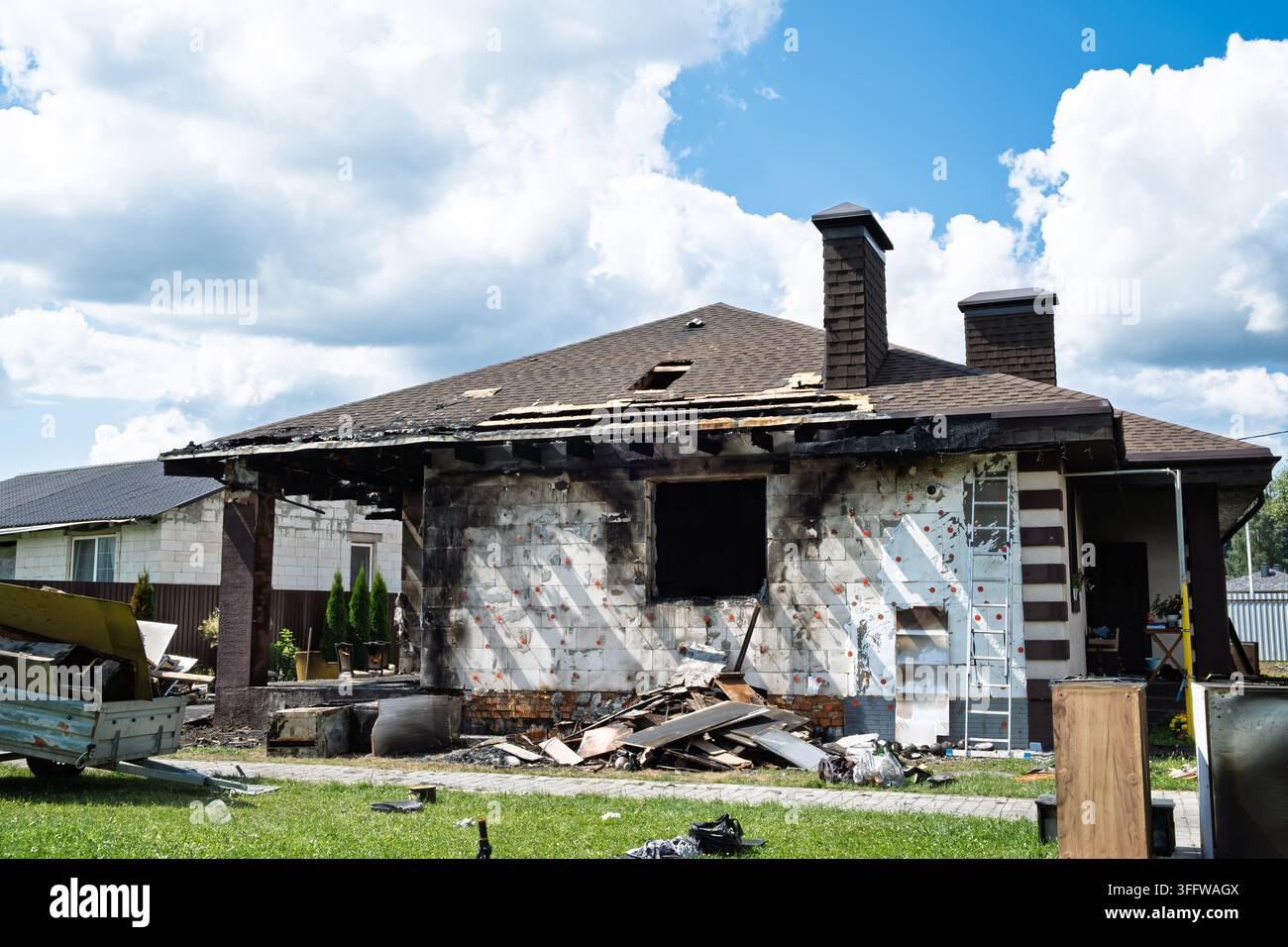 Minsk, Bielorussia - 24 luglio 2026. Casa privata danneggiata e bruciata dopo un incendio. Buco nel tetto. Finestra rotta. Mobili gettati all'aperto. Batteria o gas Foto Stock