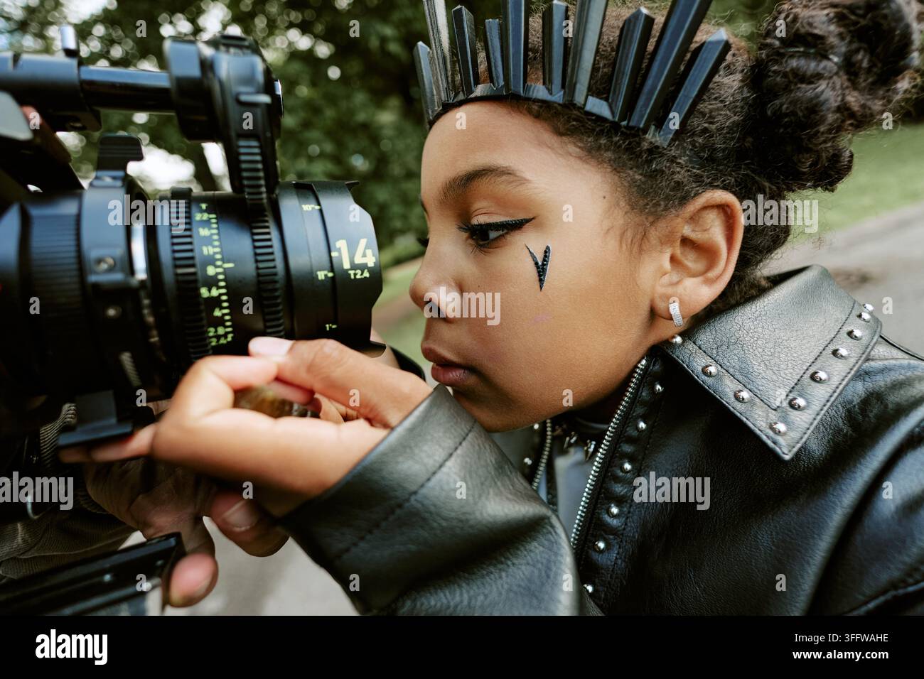 Ragazza nera che opera una videocamera professionale sul set cinematografico Foto Stock