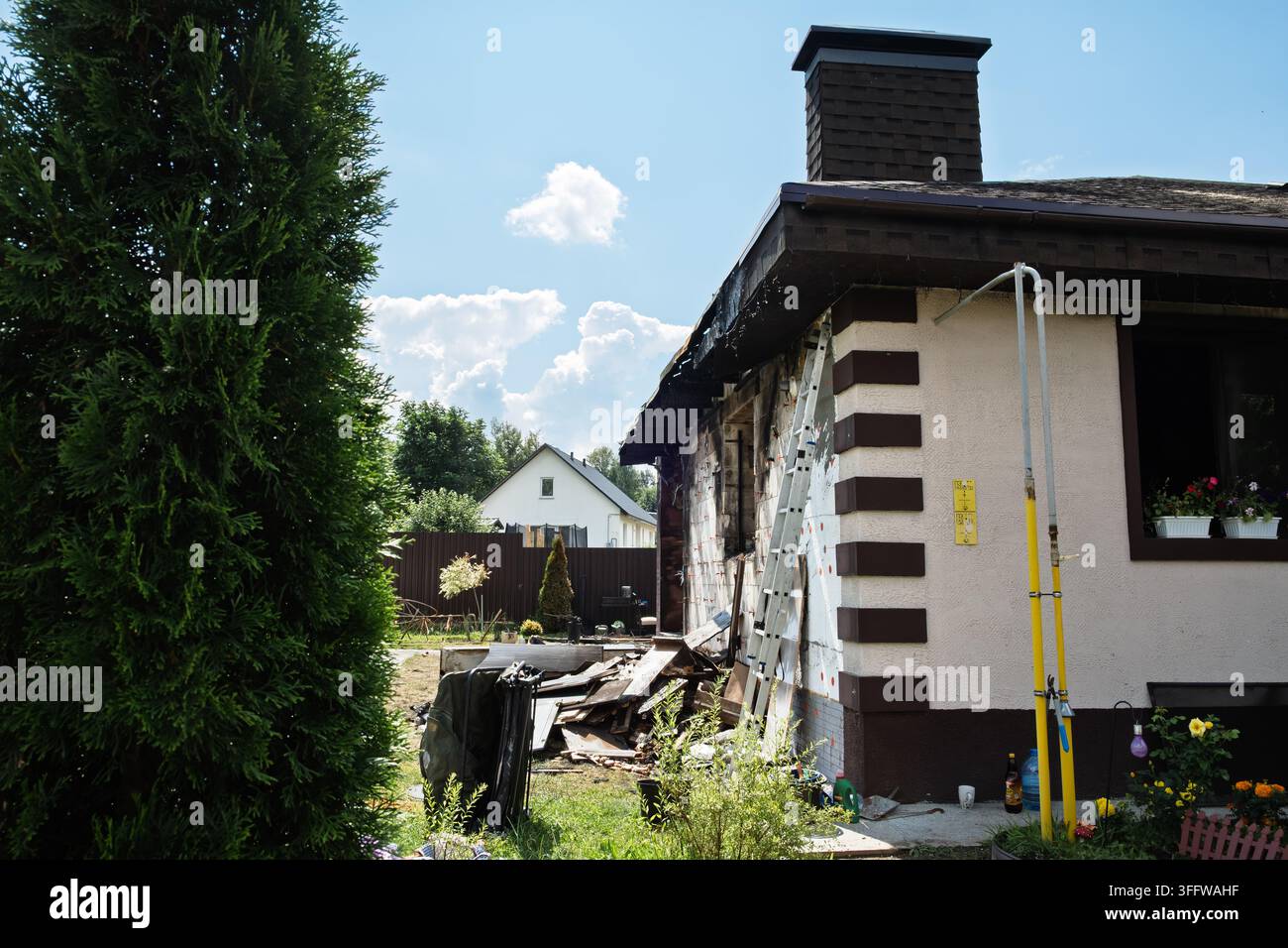 Minsk, Bielorussia - 24 luglio 2026. Casa privata danneggiata e bruciata dopo un incendio. Buco nel tetto. Finestra rotta. Mobili gettati all'aperto. Batteria o gas Foto Stock