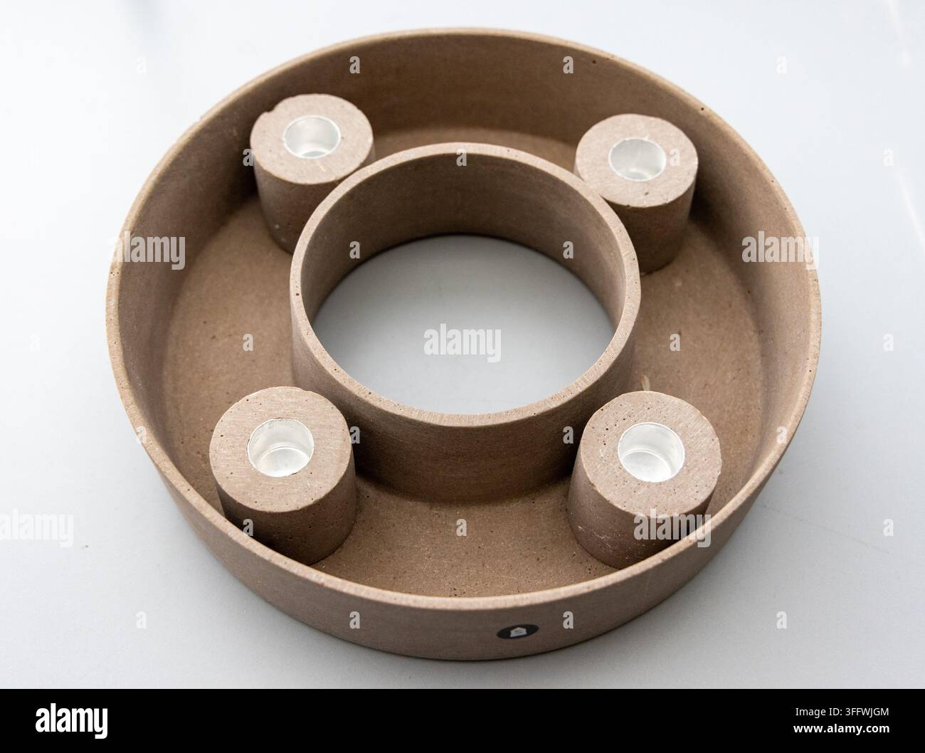 Un portacandele circolare marrone presenta quattro fessure per candele tea light Foto Stock