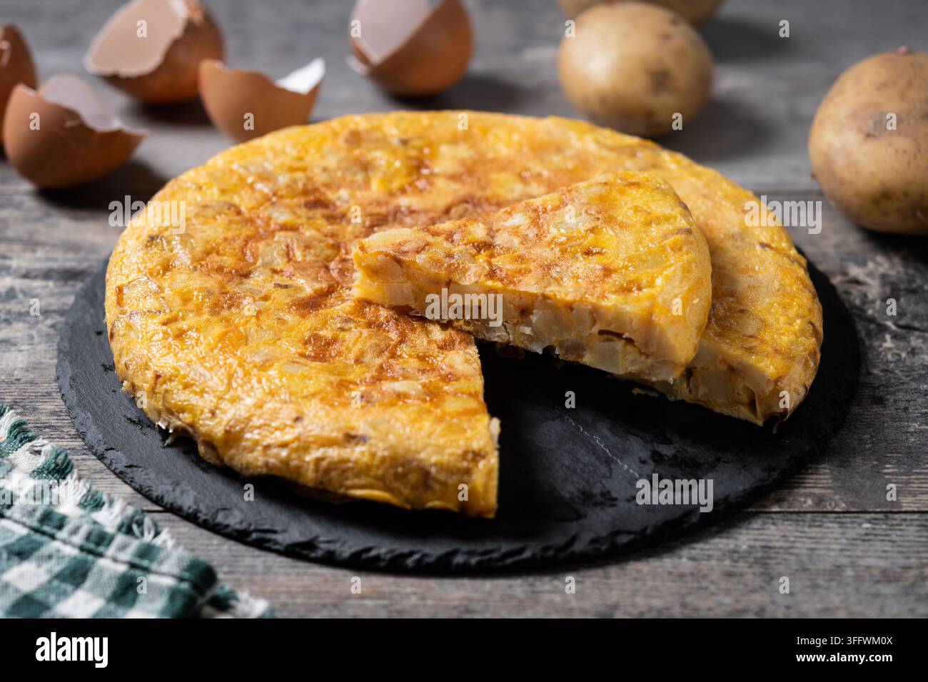 Frittata spagnola di patate e ingredienti su tavolo di legno Foto Stock