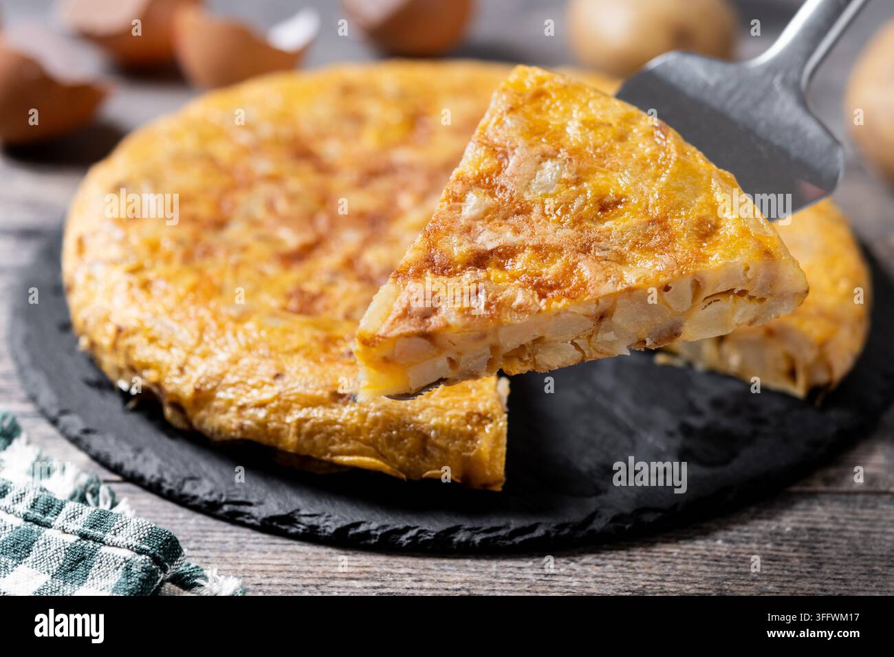 Frittata spagnola di patate e ingredienti su tavolo di legno Foto Stock