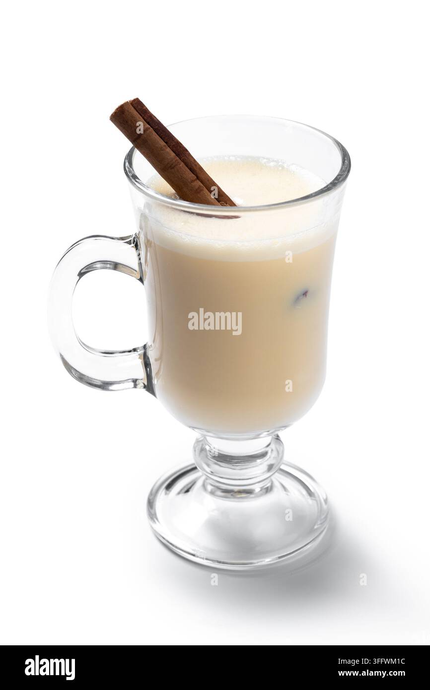 Bicchiere di eggnog con bastoncini di cannella isolati su sfondo bianco Foto Stock