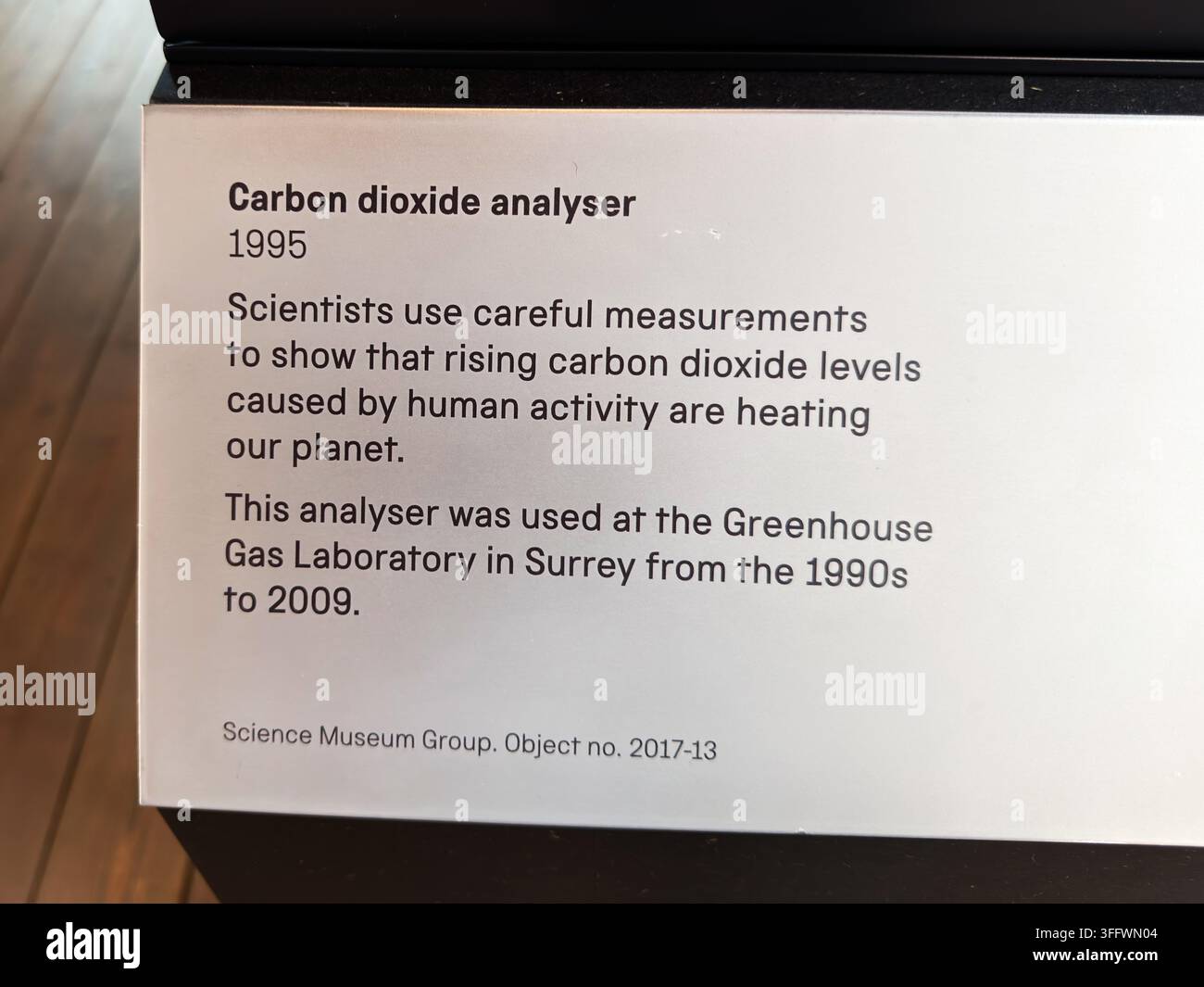Manchester, Regno Unito - 2 luglio 2026: Etichetta espositiva che spiega un analizzatore di anidride carbonica del 1995 utilizzato per misurare l'aumento del CO2 al Museo della Scienza di Manchester Foto Stock