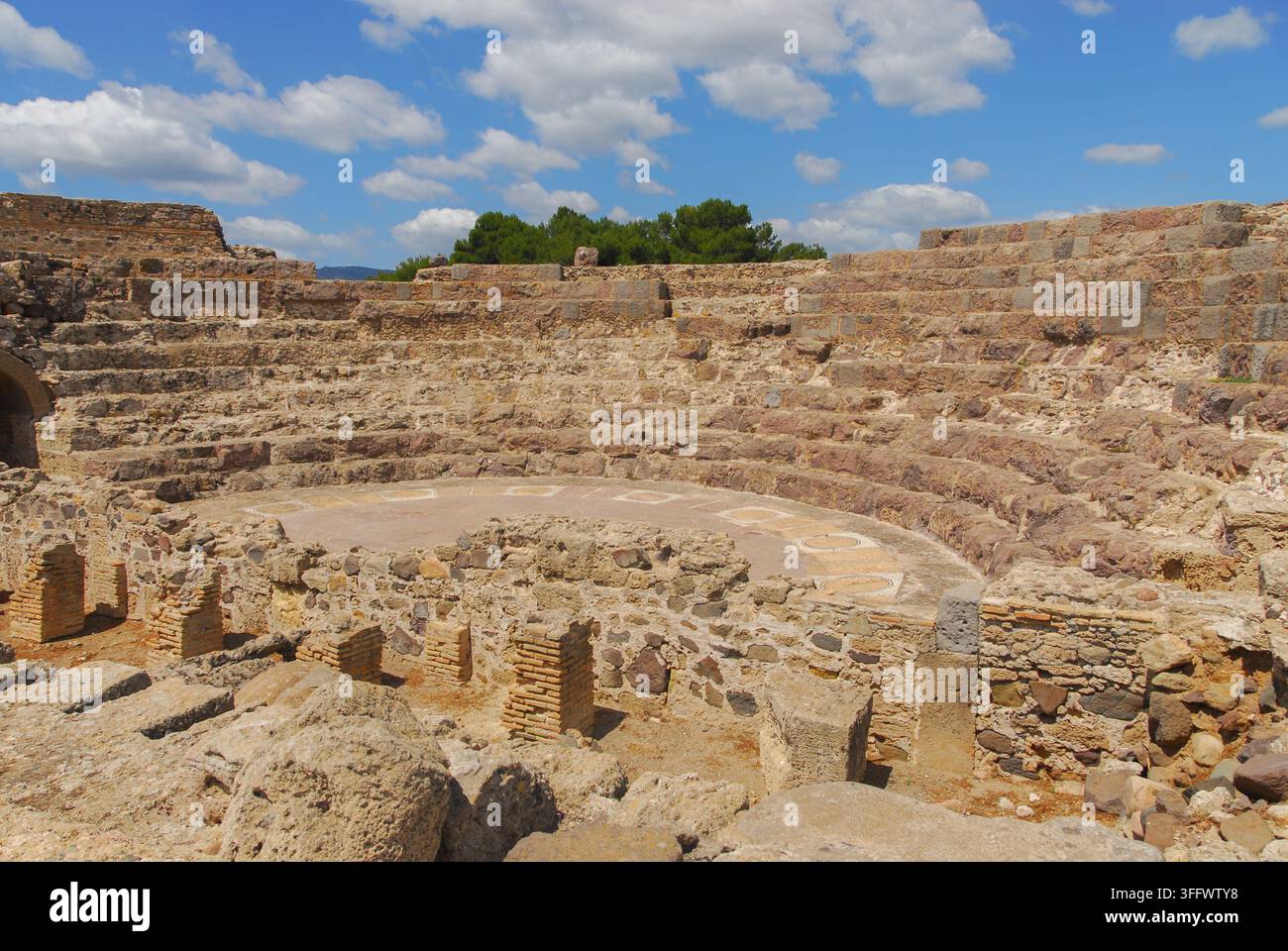 Sedili in pietra a gradini e pavimento a mosaico dell'orchestra del teatro romano nel sito archeologico di Nora, Sardegna, Italia. Foto Stock