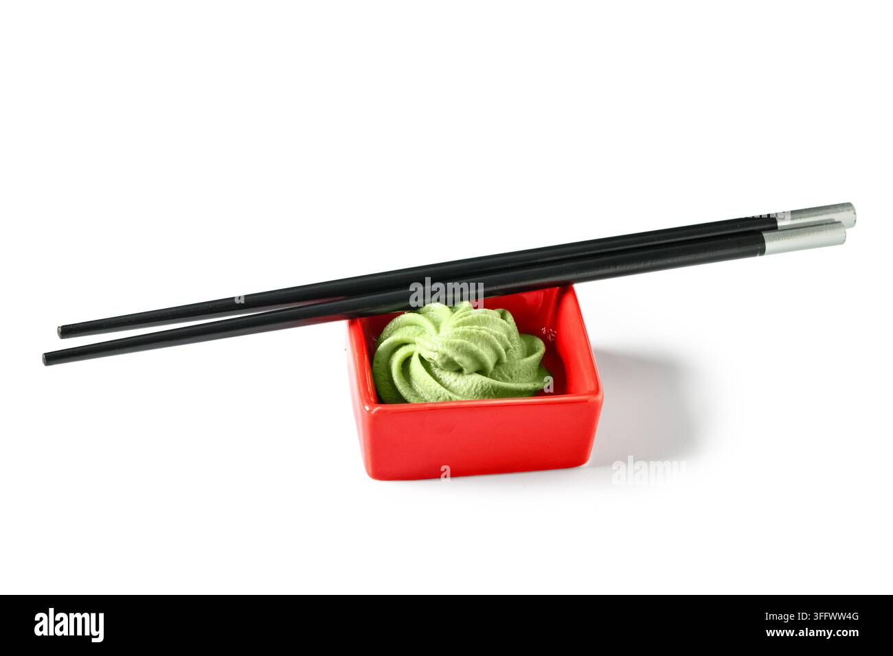 Cucina giapponese e condimenti per sushi, pasta di wasabi fresca in una piccola ciotola di ceramica rossa con bacchette nere per la sala da pranzo e il servizio di ristorante Foto Stock