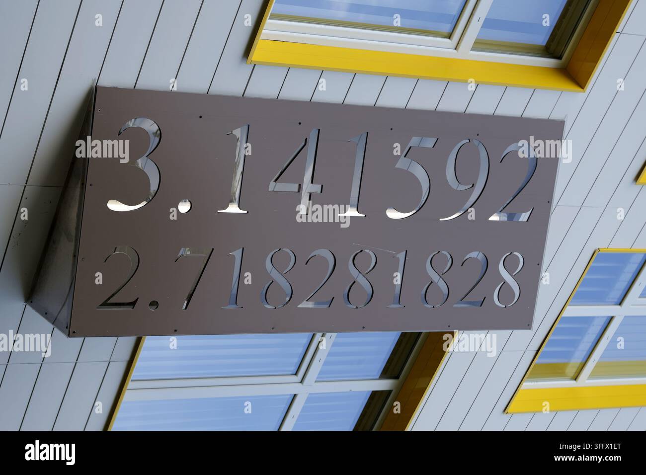 Insegna decorativa che mostra le costanti matematiche pi e il numero di Euler su una facciata di edificio moderno, simboleggiando scienza ed educazione. Bulgaria, burg Foto Stock