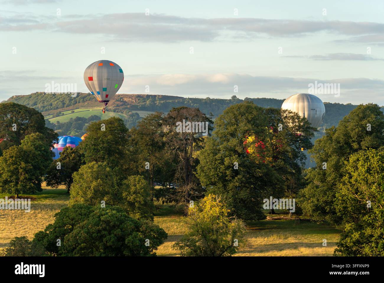 Bakewell, Regno Unito - 05 settembre 2026: Vista di palloni aerostatici che fluttuano sopra il parco di Chatsworth House con alberi verdi lussureggianti e colline ondulate Foto Stock