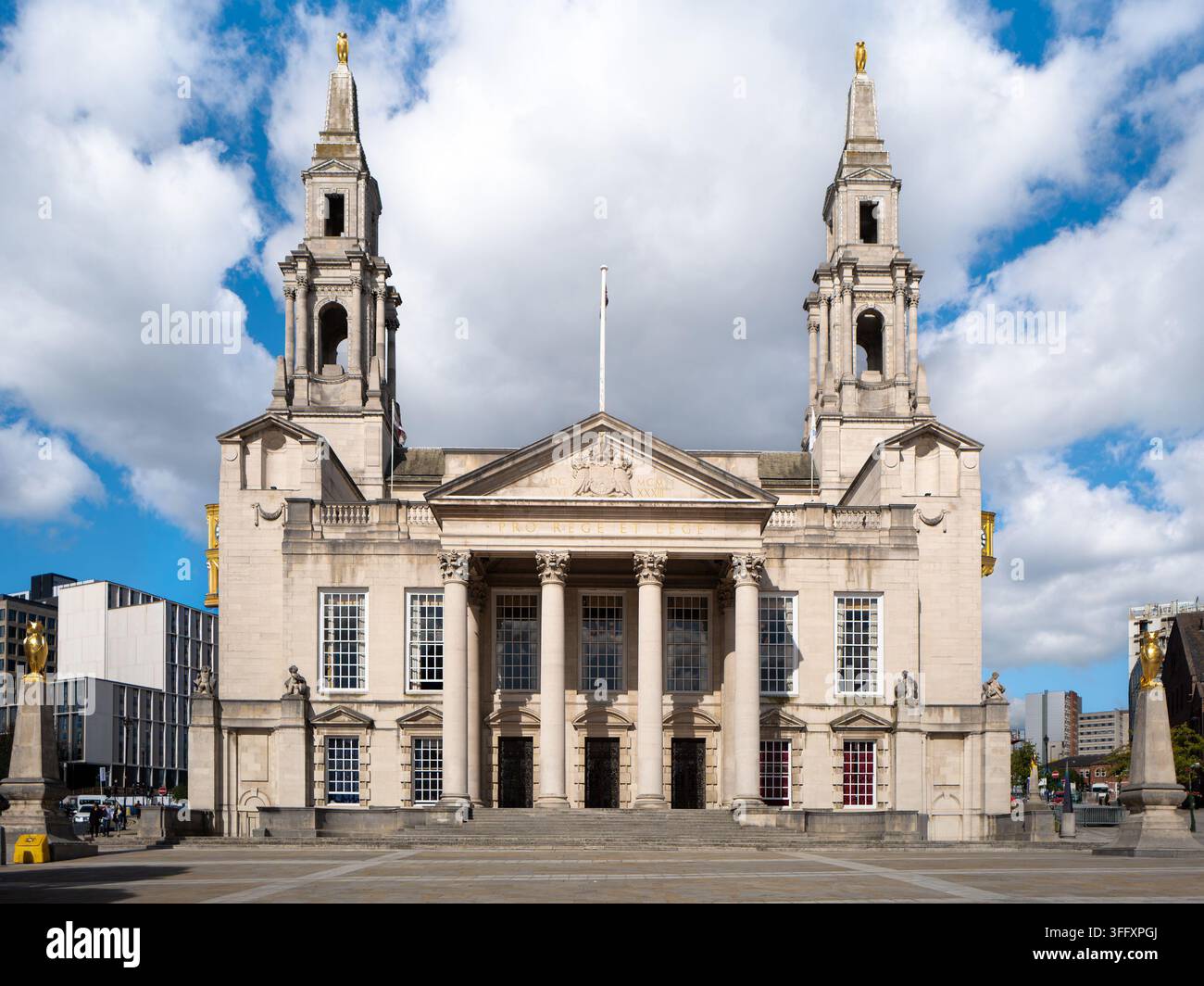 Leeds Civic Hall vista attraverso Millennium Square, affiancata da statue di gufi dorati su plinti di pietra, Leeds, West Yorkshire, Inghilterra, Regno Unito Foto Stock