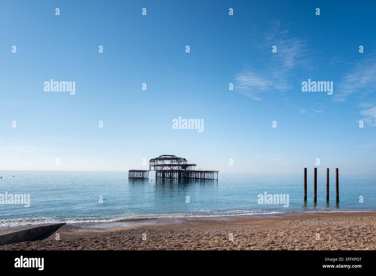 I resti scheletrici in ferro del West Pier di Brighton danneggiato da un incendio si ergono nelle acque calme del mare, East Sussex, Inghilterra, Regno Unito Foto Stock