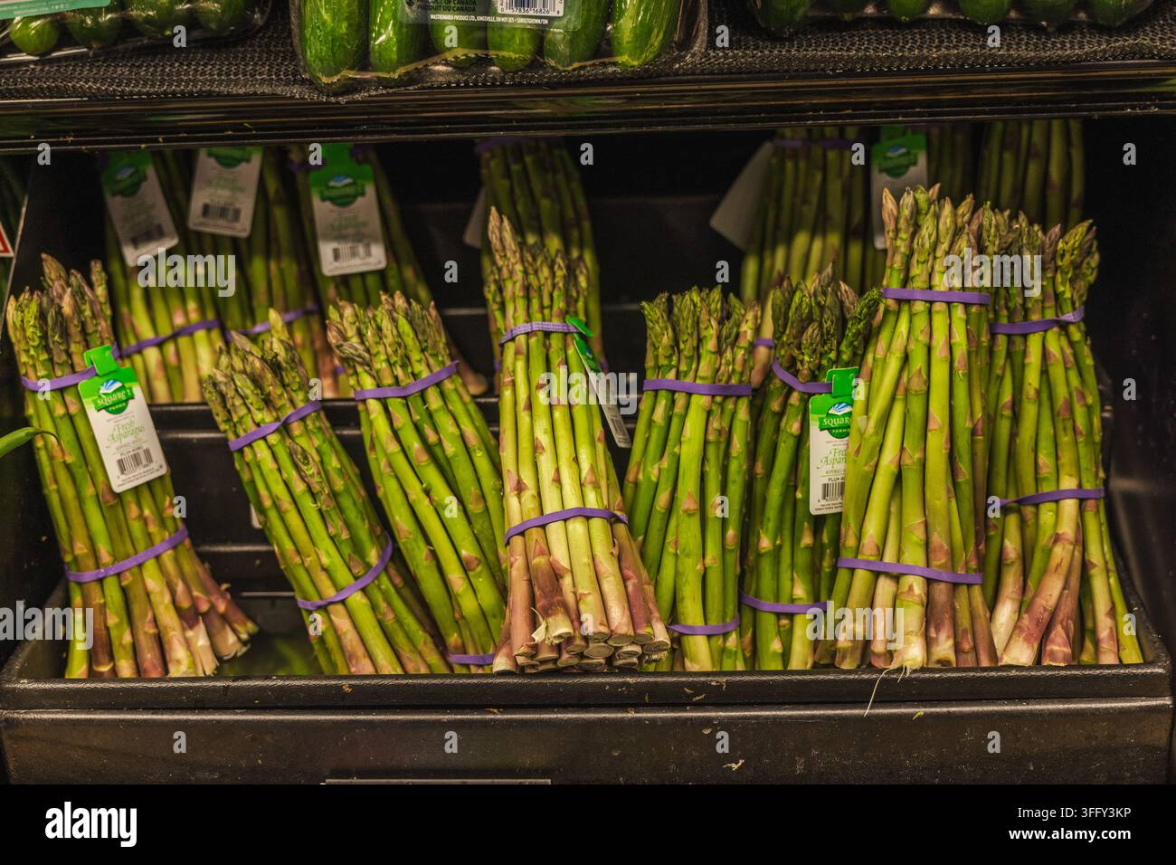 Display a distanza ravvicinata di asparagi freschi legati in un negozio di alimentari Foto Stock