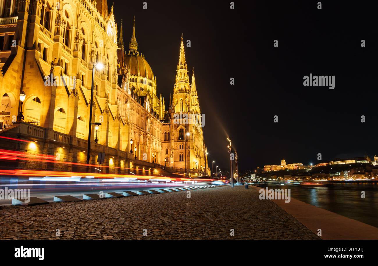 Scatto drammatico a lunga esposizione del Parlamento illuminato di Budapest sul Danubio di notte. Architettura ungherese iconica e tra Foto Stock