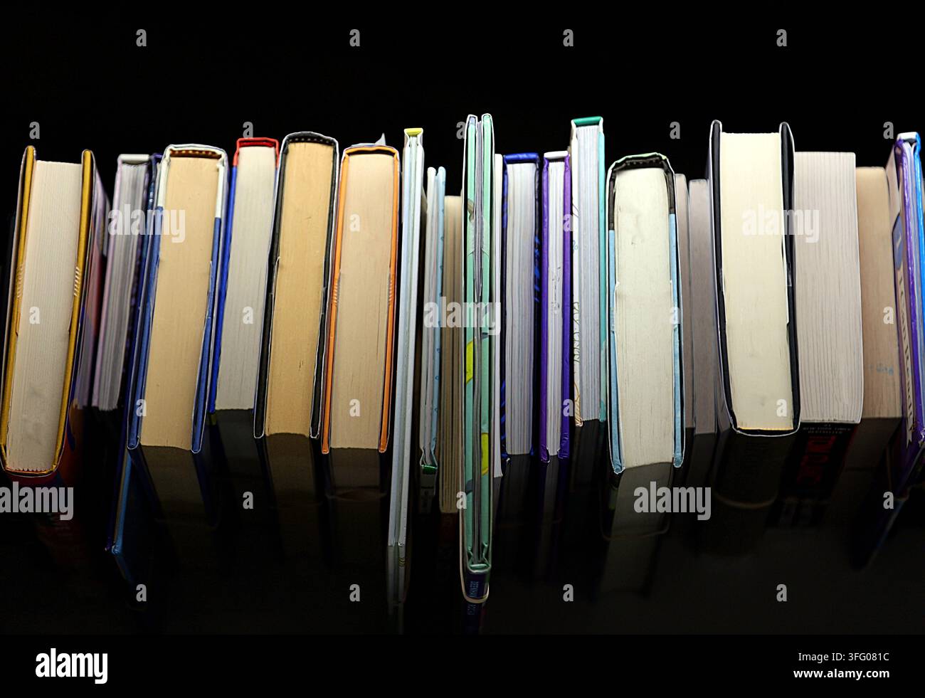 Trama di sfondo astratta senza cuciture di dorsi e pagine di libri colorati. Foto Stock