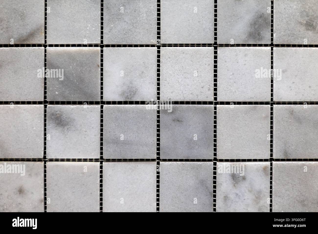Piastrella a mosaico quadrata in marmo bianco e grigio. Vista ravvicinata di piastrelle a mosaico in marmo bianco e grigio disposte in un motivo a griglia quadrata. Foto Stock