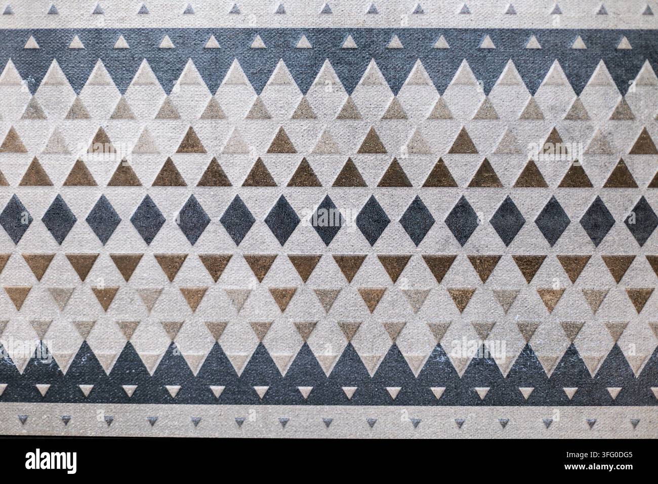 Motivo geometrico a triangoli e rombi in toni neutri. Vista ravvicinata di un motivo geometrico neutro con triangoli e rombi ripetuti in beige Foto Stock