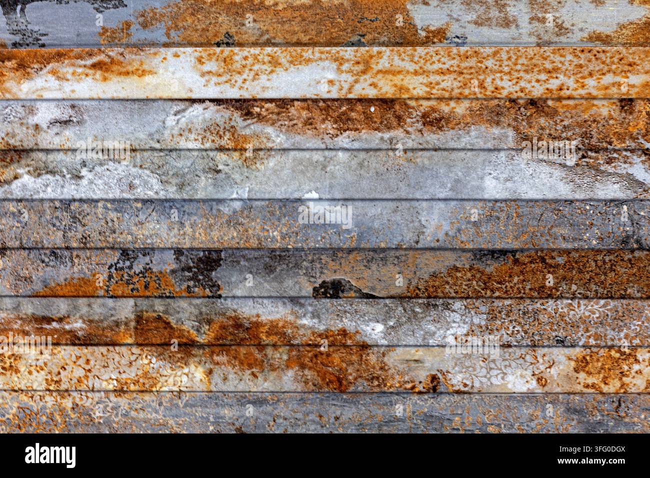 Pannelli metallici arrugginiti e patinati con patina industriale. Vista ravvicinata di strisce metalliche consumate con superfici grigie, ruggine arancione, corrosione e macchie irregolari Foto Stock