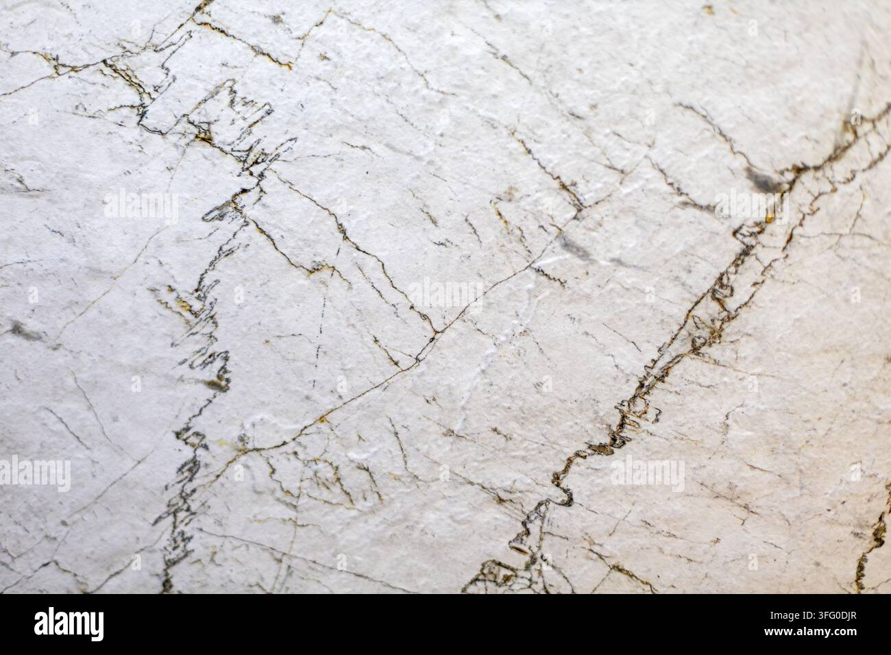 Texture di marmo bianco con sottili venature scure naturali. Close-up di pietra di marmo bianco con sottili venature scure, crepe e una texture naturale sottile. Foto Stock