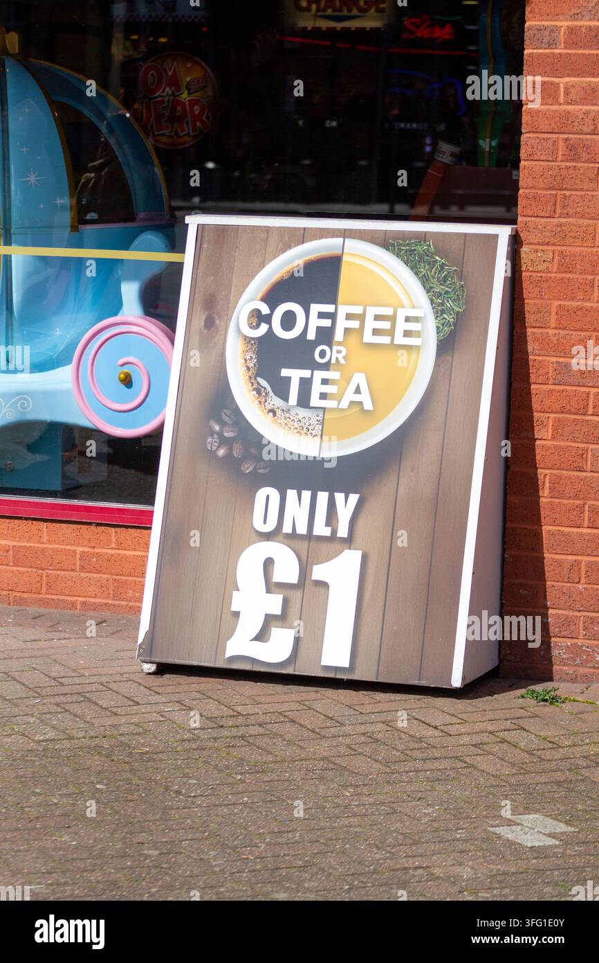 Un cartello sandwich in legno fuori da un negozio che pubblicizza bevande calde con un logo circolare "COFFEE OR TEA" e "SOLO £1". Southport, UK. Foto Stock