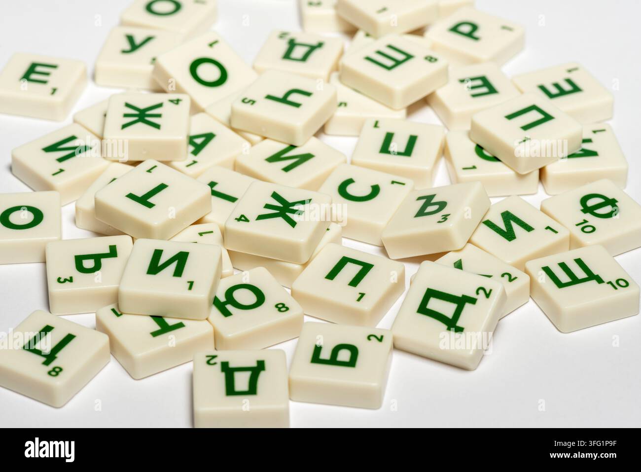 Tesserae sparse di lettere cirilliche con lettere verdi su pezzi bianchi, tessere del gioco da tavolo Scrabble in lettere cirilliche bulgare Foto Stock