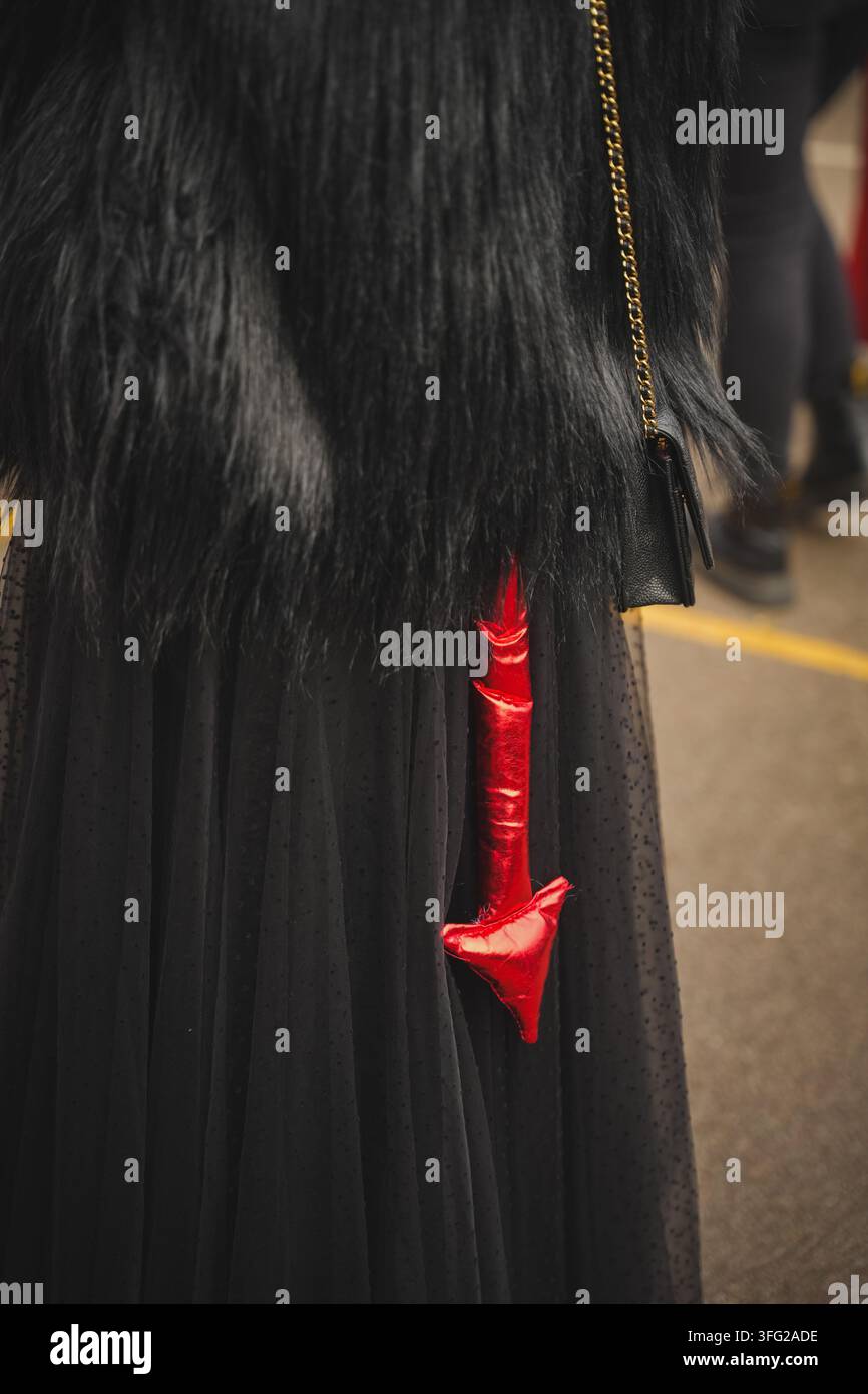 Coda di diavolo rossa attaccata a un costume di Halloween nero. Foto Stock