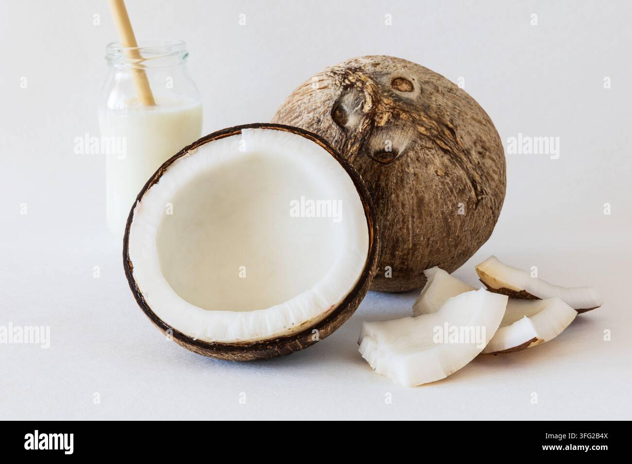 Noce di cocco e yogurt al cocco, intere e tagliate a metà, con polpa fresca Foto Stock