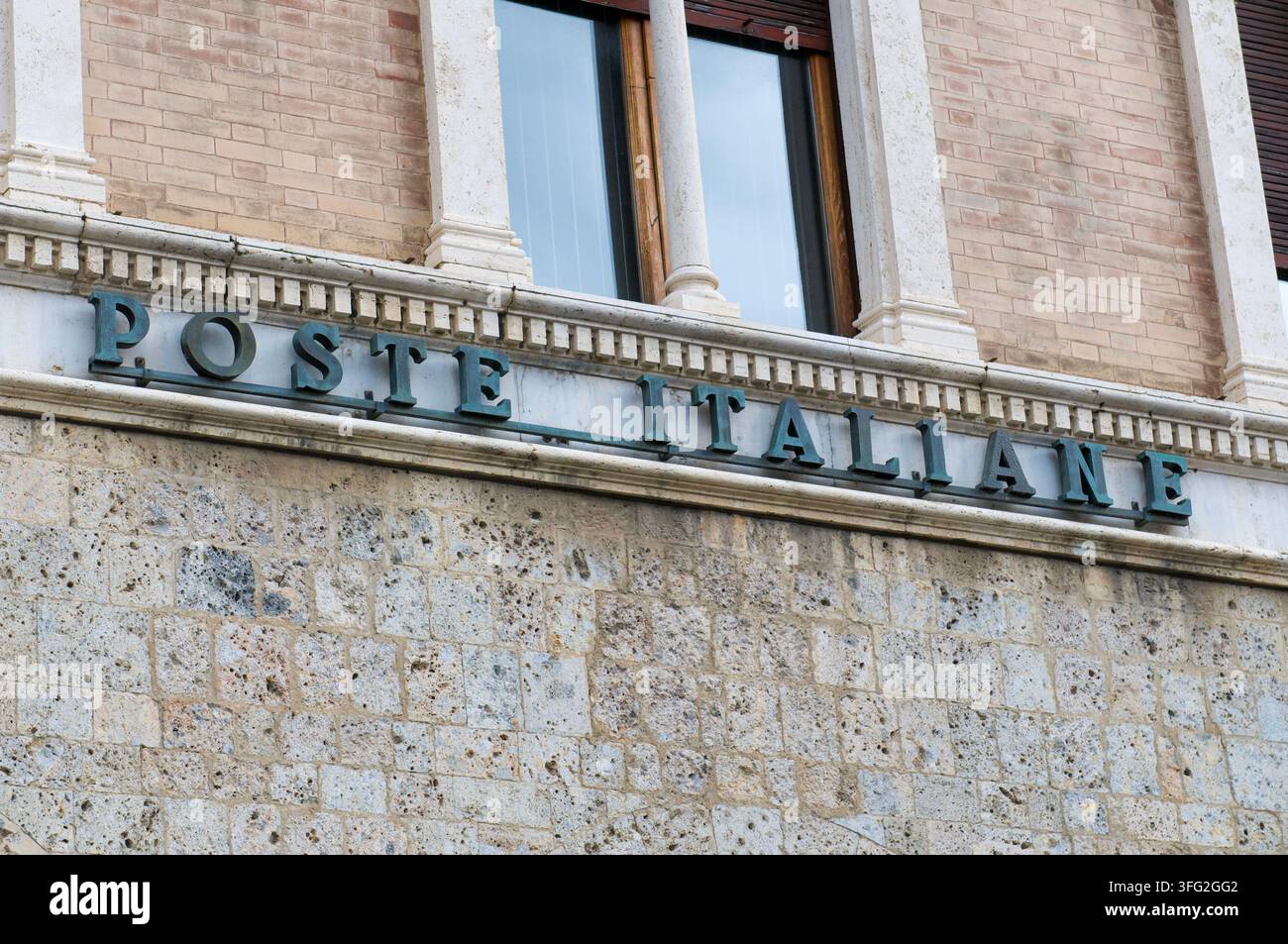 Siena, Toscana, Italia – 8 ottobre 2021: Insegna vintage con lettere metalliche di Poste Italiane sulla facciata in pietra dell'edificio centrale dell'ufficio postale. Foto Stock