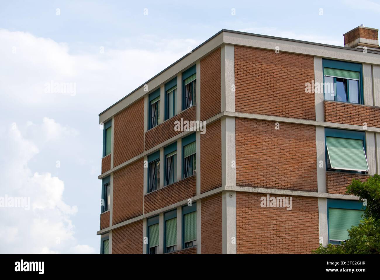 Facciata di un edificio residenziale con pareti in mattoni rossi a Cassarate, Lugano, Svizzera. Concetto per investimenti immobiliari, edilizia urbana Foto Stock