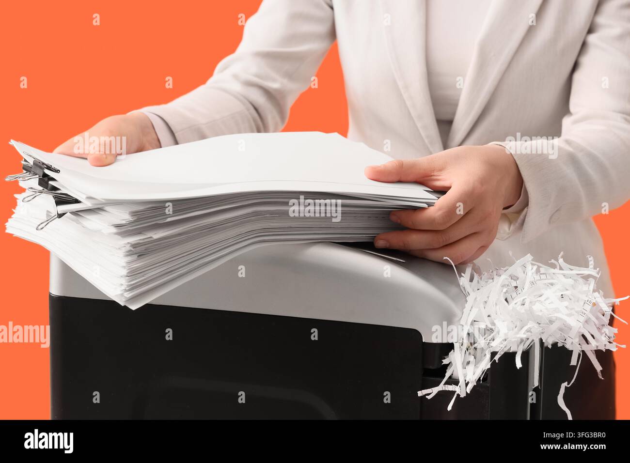 Protezione dei dati e sicurezza dei documenti, donna d'affari che distrugge documenti riservati per prevenire il furto d'identità e proteggere le informazioni sensibili aziendali Foto Stock