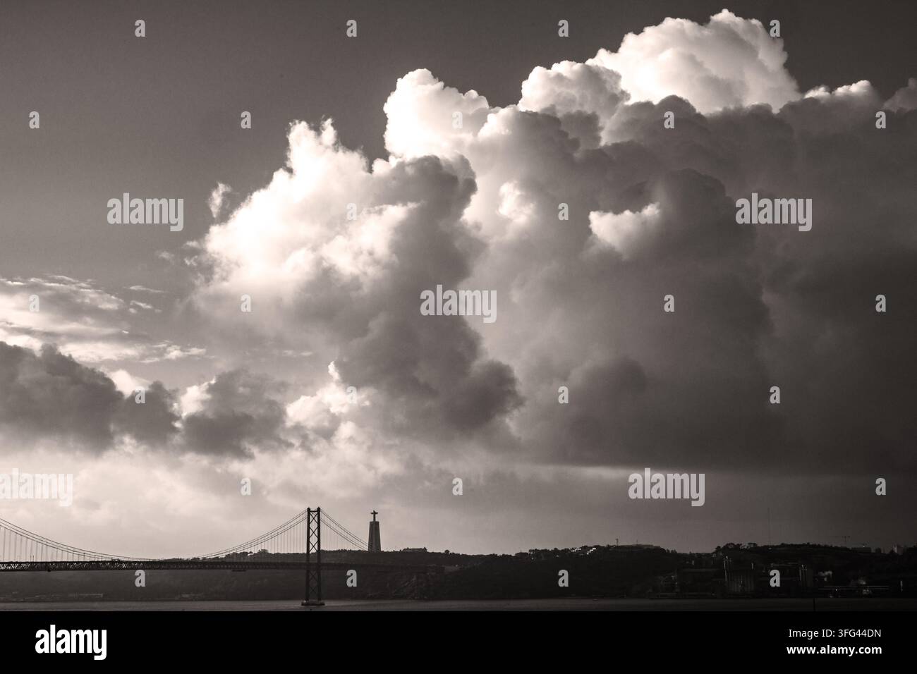 Nuvole drammatiche sopra il Ponte 25 de Abril e Cristo Rei, Lisbona, cielo in bianco e nero, atmosfera monocroma Foto Stock