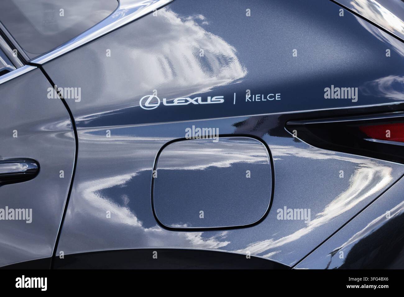 Primo piano di un'auto Lexus con il logo del concessionario sul pannello laterale, che riflette le nuvole sulla sua carrozzeria blu scuro Foto Stock