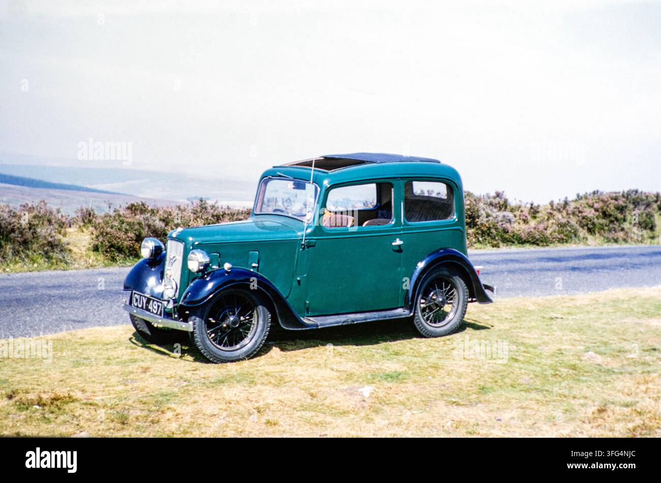 Auto Austin 7 Ruby Saloon parcheggiata su un bordo erboso in una zona collinare, Inghilterra, Regno Unito, anni '60 Foto Stock