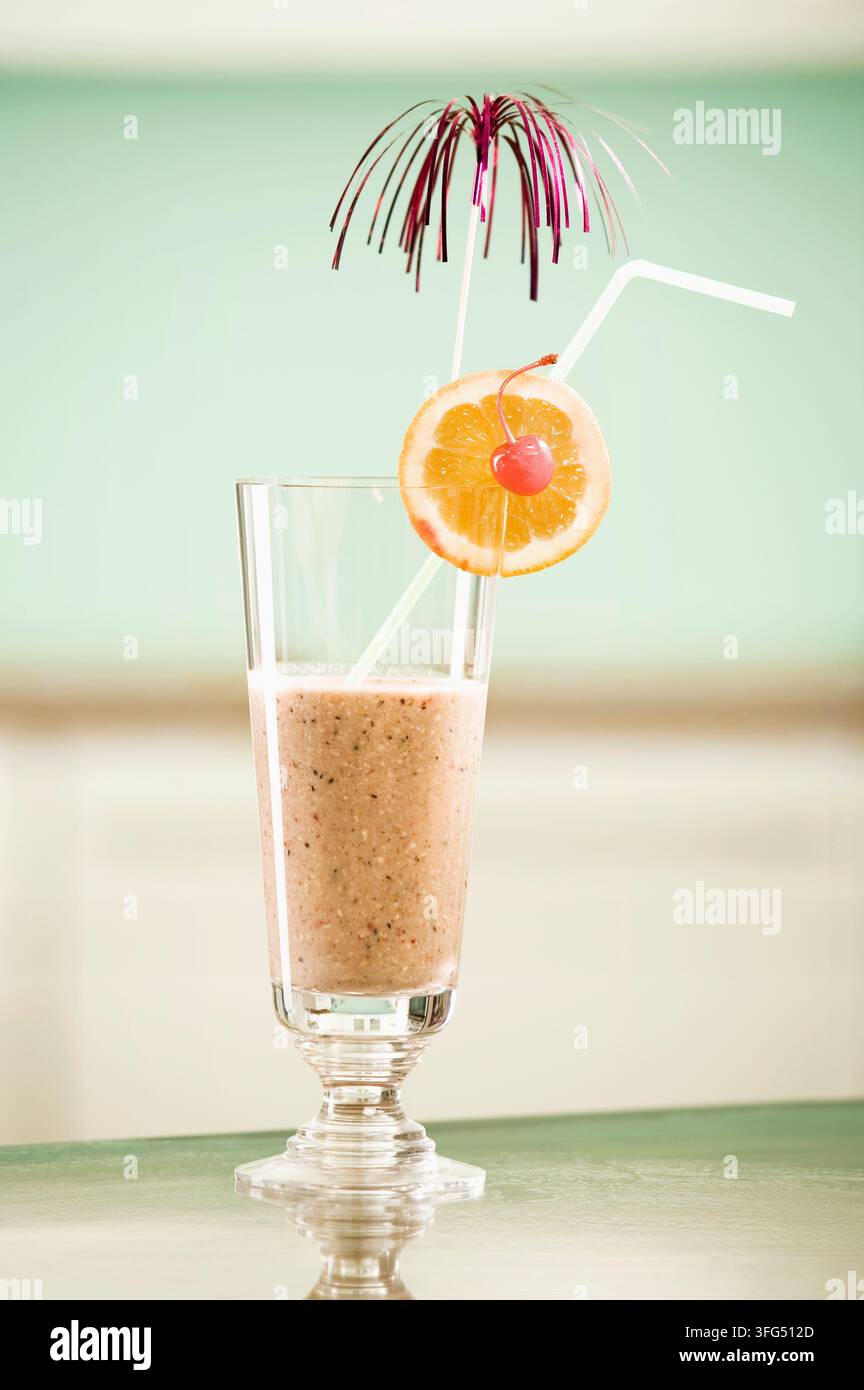 Frullato proteico nutriente servito in un bicchiere alto con agrumi Foto Stock
