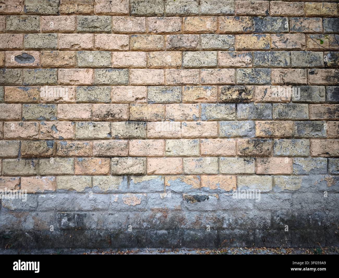 Muro di mattoni con weathering naturale o danni alla base. Foto Stock