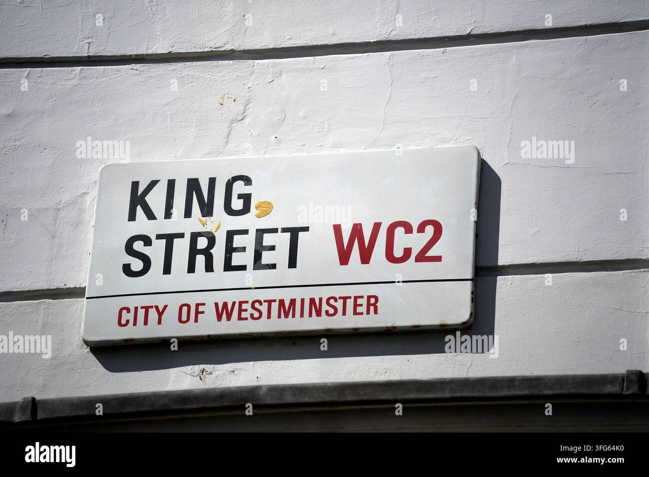 Primo piano di un cartello stradale bianco della City of Westminster per King Street WC2 montato su un muro dipinto di bianco a Londra. Foto Stock