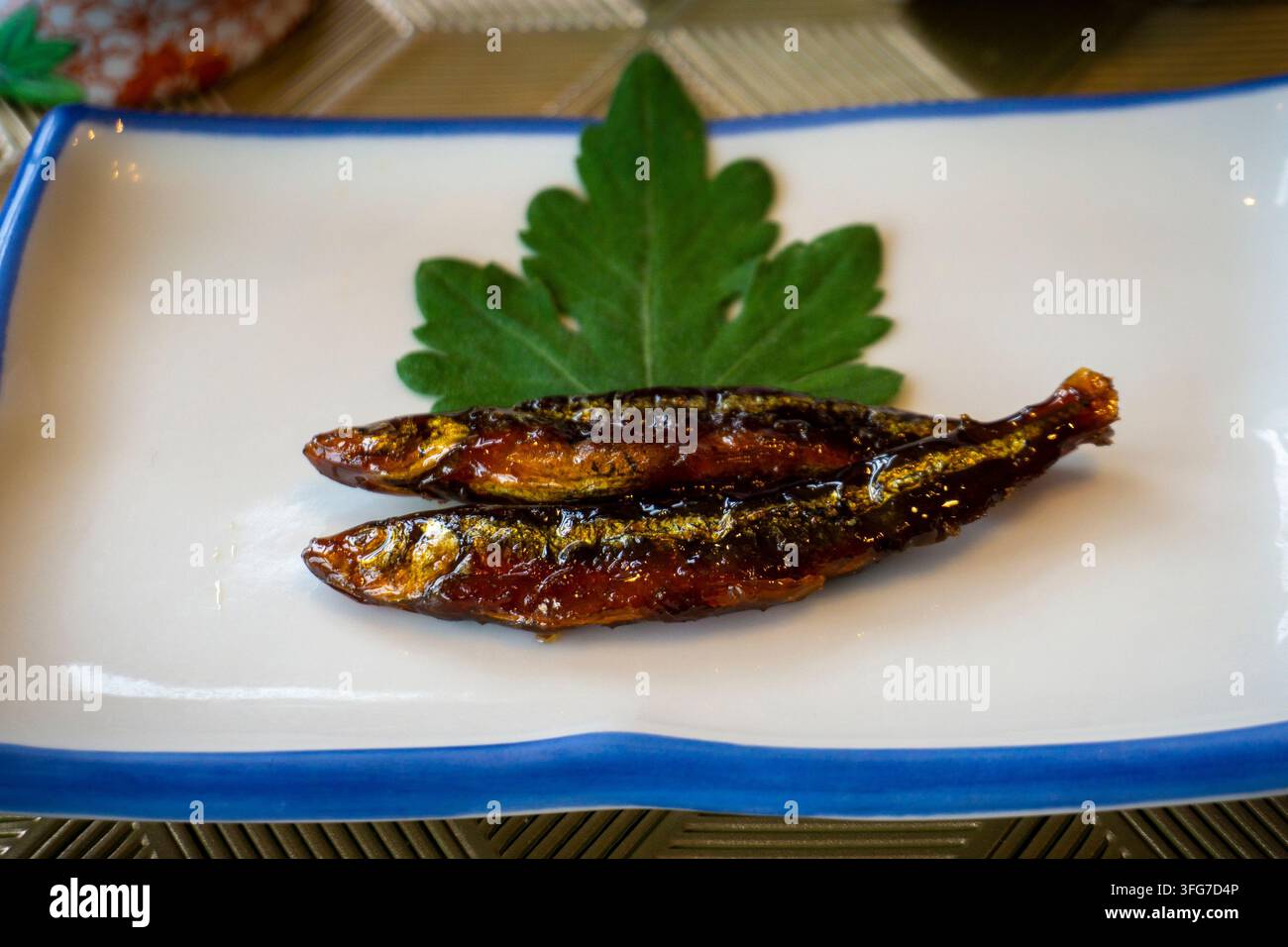 Piatto tradizionale di Hokkaido conosciuto come Shishamo kanroni, un piatto di alosa dolce e salato cotto a fuoco lento in una salsa addolcita a base di sakè, mirin, zucchero e salsa di soia Foto Stock