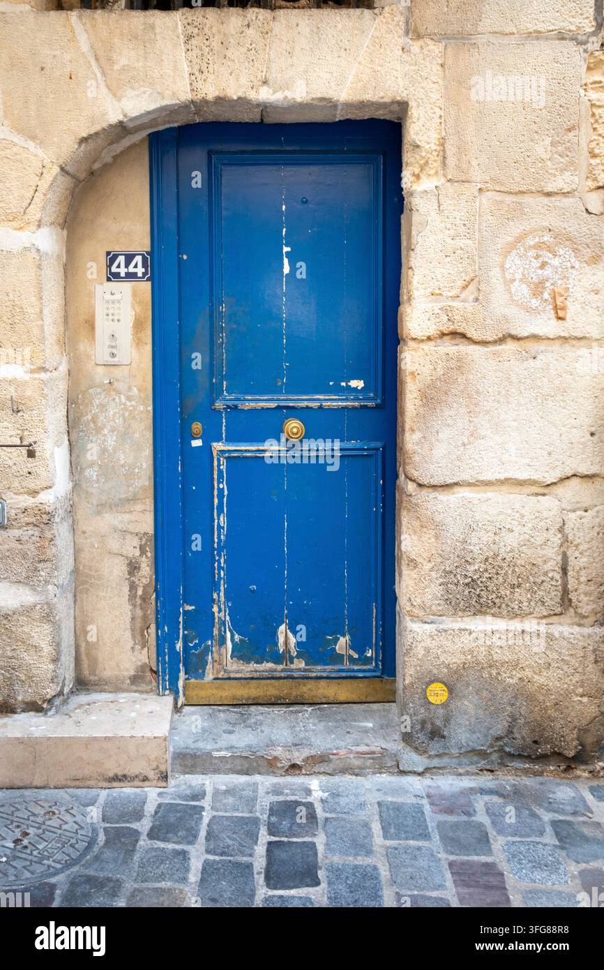 Porta di legno blu consumata con numero civico 44, incastonata in una facciata rustica storica in arenaria, Parigi, Île-de-France, Francia Foto Stock