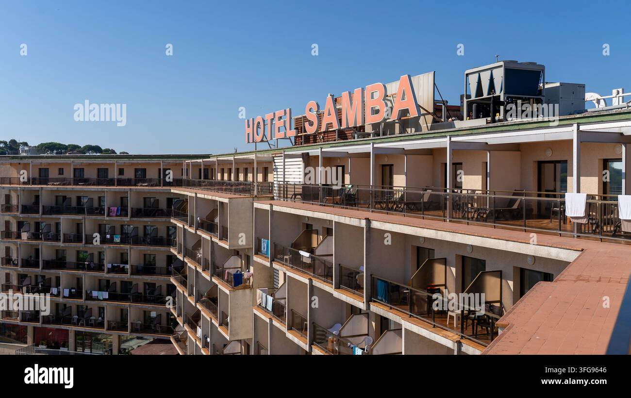 Lloret de Mar, Spagna, 4 settembre 2026: Vista ravvicinata dell'esterno dell'Hotel Samba con insegna sul tetto, balconi, terrazze e camere d'albergo sotto un blu chiaro Foto Stock