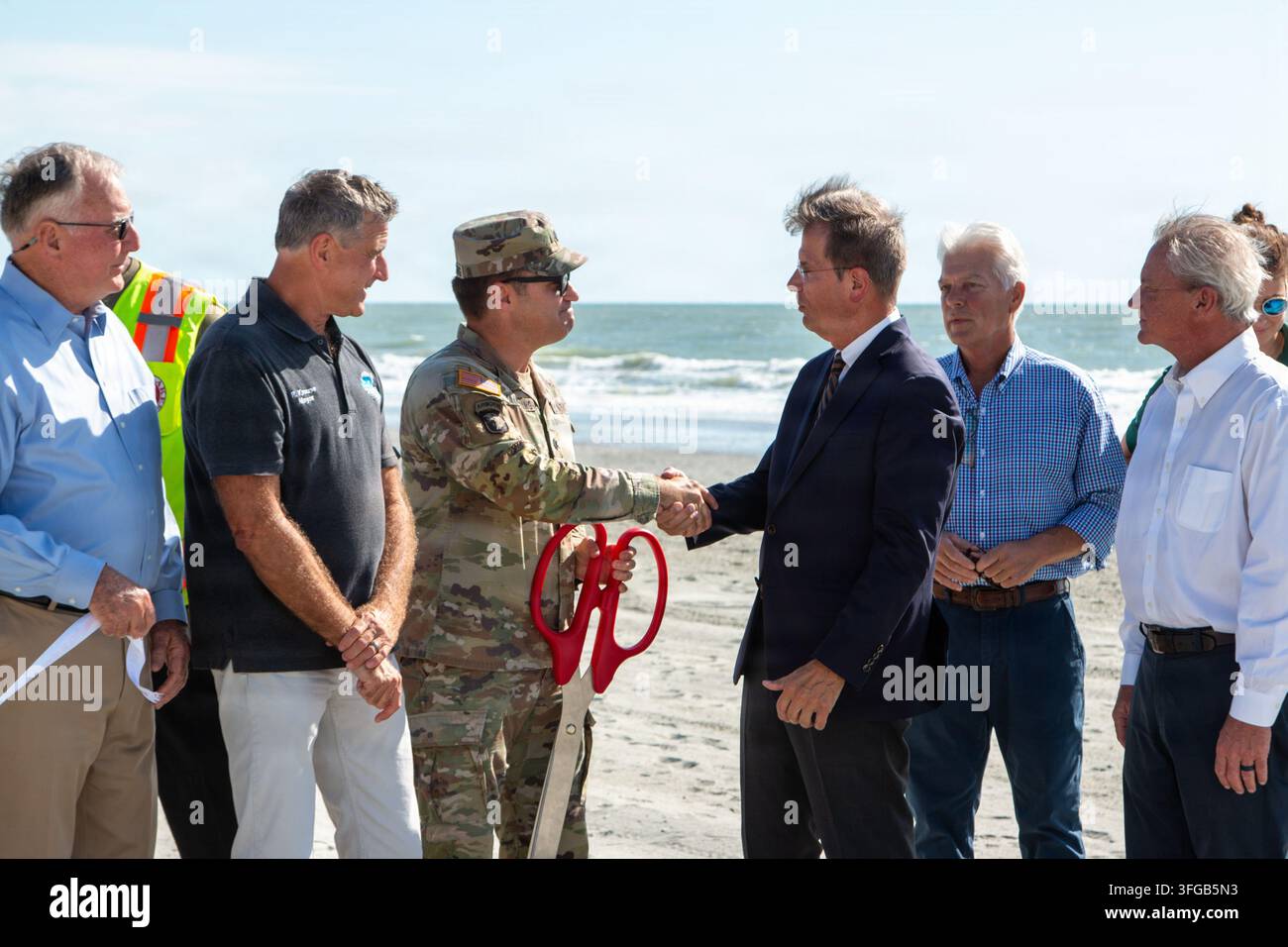 Il tenente colonnello dell'esercito americano Todd Mainwaring, comandante del U.S. Army Corps of Engineers, distretto di Charleston, stringe la mano al sindaco di Myrtle Beach Mark Kruea durante una cerimonia di taglio del nastro a Surfside Beach, South Carolina, il 9 settembre 2026, segnando il completamento del Grand Strand Renourishment Project, che ha aggiunto 2,15 milioni di cubici di sabbia a 28 miglia di lungomare pubblico per proteggere le infrastrutture e l'economia turistica locale. Foto Stock
