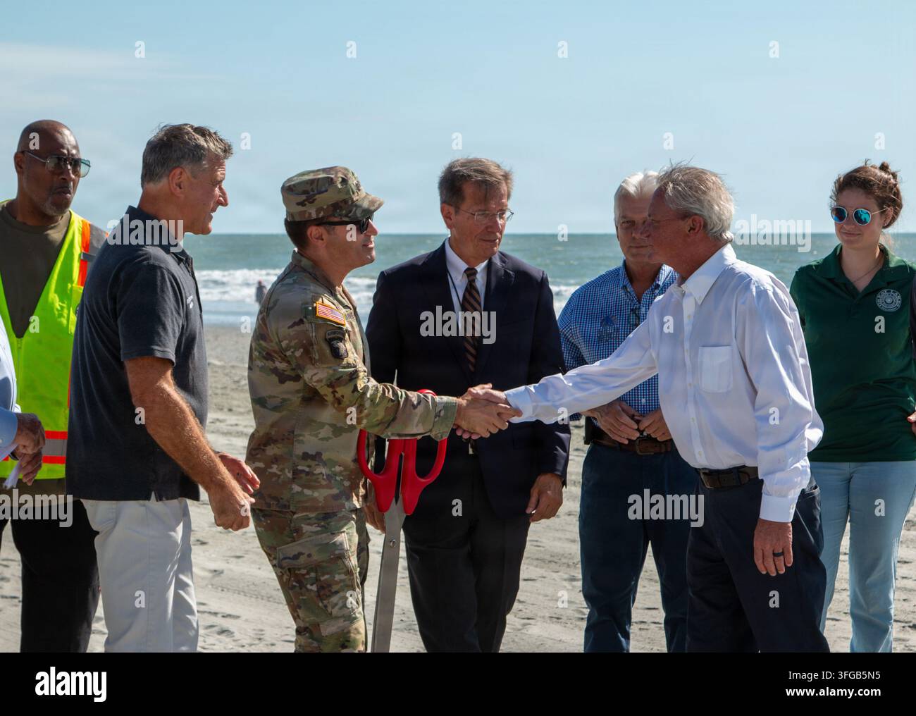 Il tenente colonnello dell'esercito americano Todd Mainwaring, comandante del U.S. Army Corps of Engineers, distretto di Charleston, saluta il sindaco di North Myrtle Beach J.O. Baldwin, III, durante la cerimonia di completamento del Grand Strand Renourishment Project a Surfside Beach, South Carolina, che ha ripristinato le linee costiere da North Myrtle Beach a Garden City dopo gravi erosioni causate da uragani. Foto Stock