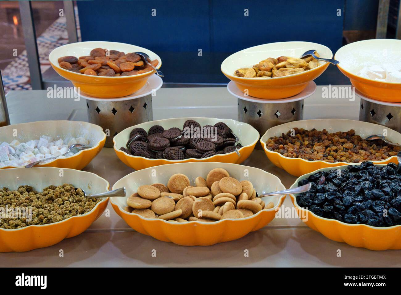 Una vista ad angolo alto di un buffet per la colazione o snack di un hotel con albicocche secche, fichi, prugne e uvetta insieme a biscotti rotondi, panini al cioccolato Foto Stock