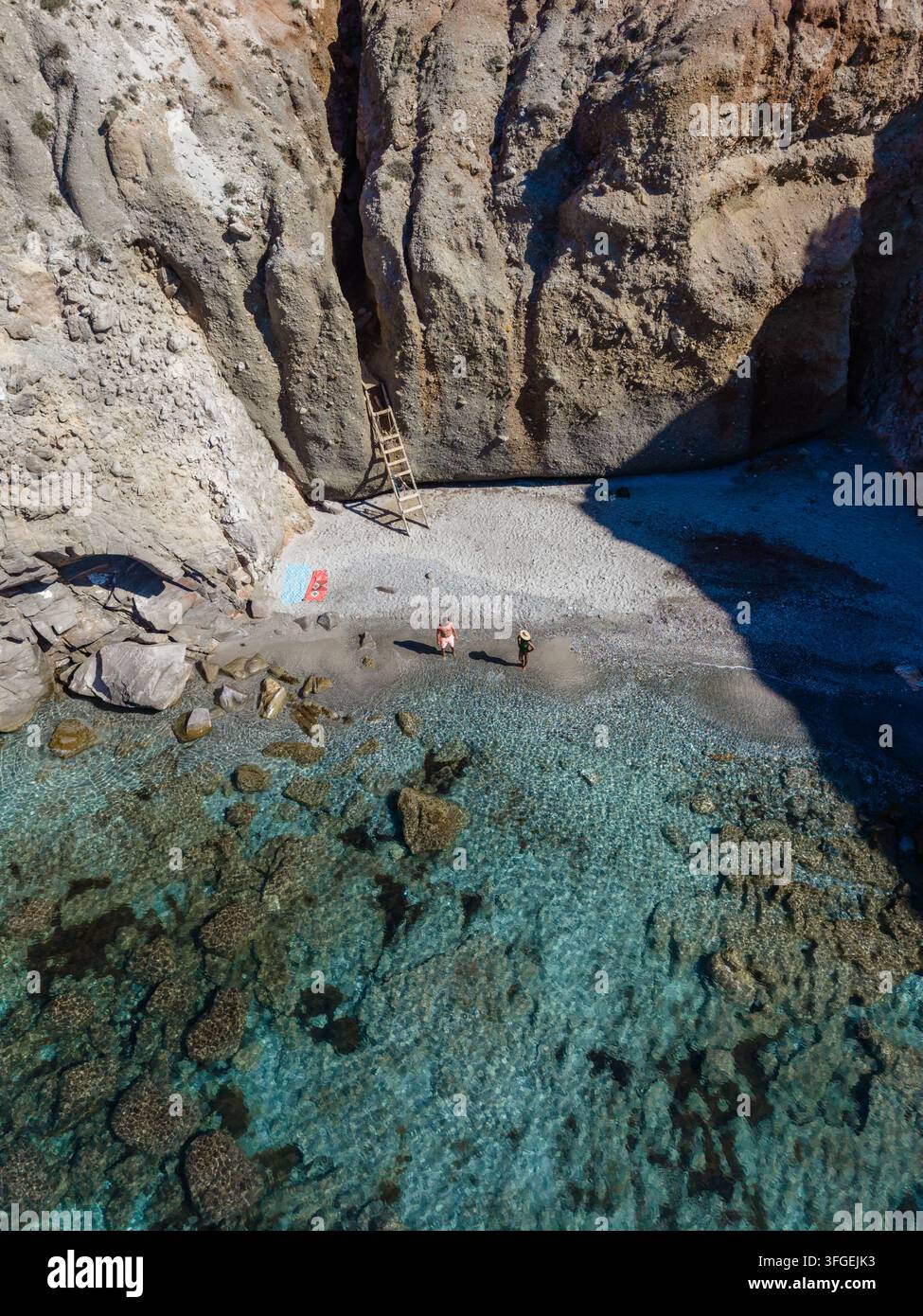 Scopri il paesaggio mozzafiato di Tsigrado Beach, circondato da imponenti scogliere e acque cristalline a Milos, Grecia. Perfetto per avventurosi so Foto Stock