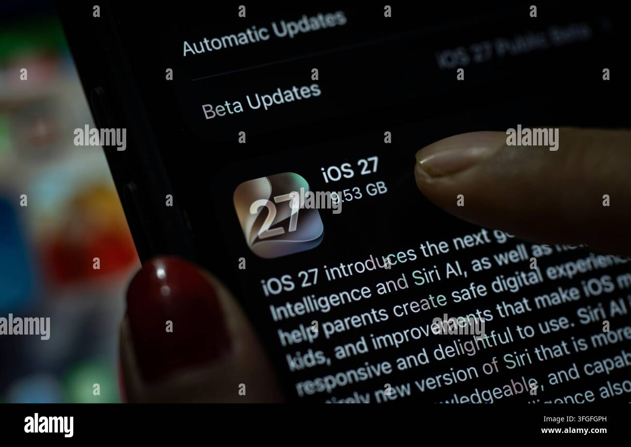 In questa illustrazione fotografica, una persona preme il pulsante "Aggiorna ora" su un iPhone che mostra lo schermo dell'aggiornamento software iOS 27, evidenziando l'ultima novità di Apple Foto Stock