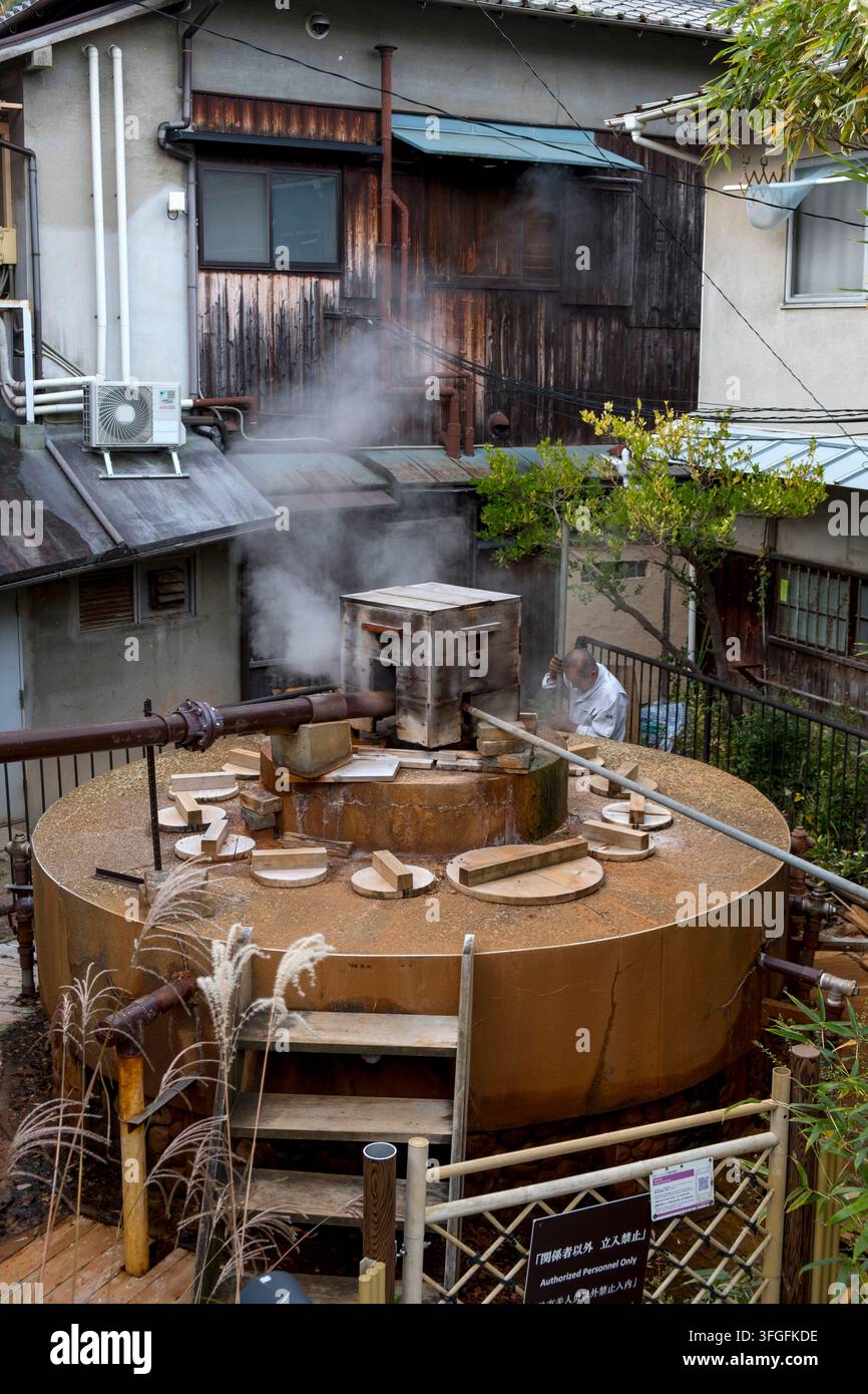 Operaio di manutenzione giapponese che controlla la sorgente termale fumante Gosho (御所泉源) nella località termale di Arima Onsen (有馬温泉), Kobe, Hyogo, Giappone. Foto Stock